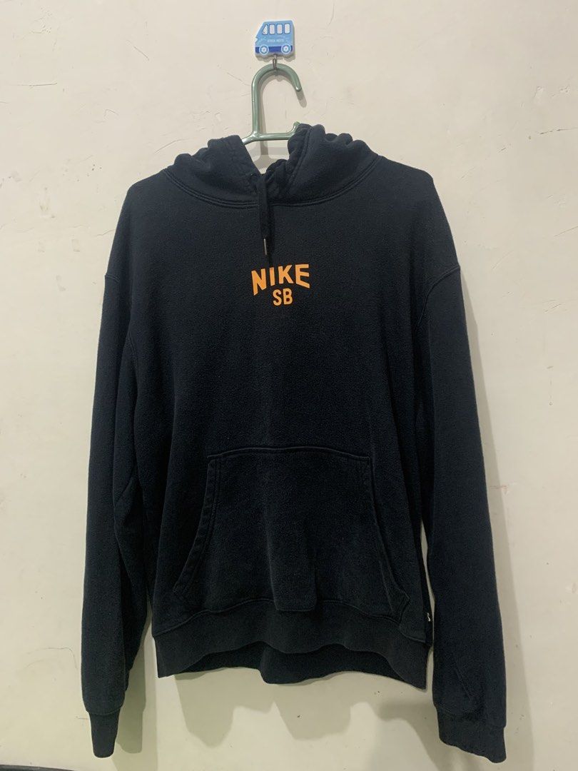 Nike SB Black Orange Hoodie (Category: Hoodies) located in Iligan City. Submitted by victhrift_shop (Listing ID 1464971699, Image 1). Description: - Brand: Nike SB - Color: Black with bright orange graphics - Design: Small chest logo and large curved text across the back - Features: Attached drawstring hood and front kangaroo pocket - Material: Comfortable cotton blend, ideal for everyday wear - Fit: Standard fit.