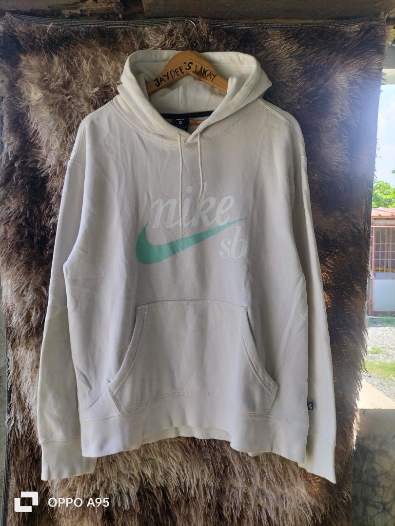 Nike SB White Hoodie Size M (Category: Hoodies) located in Baler. Submitted by jaydeebaltazar (Listing ID 1464985552, Image 2). Description: - Brand/Model: Authentic Nike SB Hoodie - Color: White with teal swoosh and script logo on chest - Size: Medium (tag on collar) - Features: Drawstring hood, front kangaroo pocket, ribbed cuffs and hem, and side seam woven label - Origin: Made in Malaysia - Condition: Clean piece, extremely comfortable for da