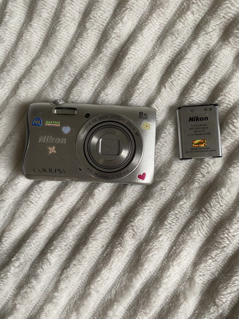 Nikon Coolpix S3700 Digital Camera with Battery and Case (Category: Cameras) located in Iloilo. Submitted by angelenepe01084 (Listing ID 1465098382, Image 3). Description: - Model: Silver Nikon Coolpix S3700 point and shoot camera - Aesthetic: Decorated with cute, fun stickers on the front and back - Ideal for: Vintage digital photography trend and everyday carry (EDC) - Inclusions: Nikon EN-EL19 rechargeable lithium-ion battery and a black zippe