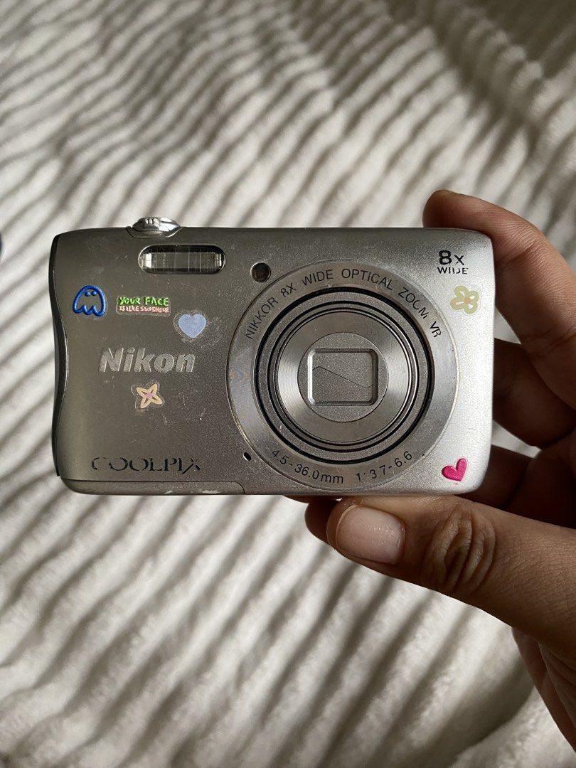 Nikon Coolpix S3700 Digital Camera with Battery and Case (Category: Cameras) located in Iloilo. Submitted by angelenepe01084 (Listing ID 1465098382, Image 2). Description: - Model: Silver Nikon Coolpix S3700 point and shoot camera - Aesthetic: Decorated with cute, fun stickers on the front and back - Ideal for: Vintage digital photography trend and everyday carry (EDC) - Inclusions: Nikon EN-EL19 rechargeable lithium-ion battery and a black zippe