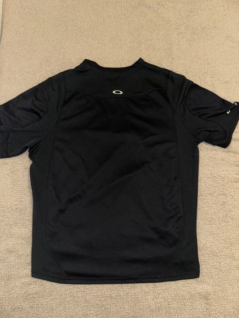 Oakley Black Half-Zip Athletic Shirt Size L (Category: Activewear) located in Quezon City. Submitted by mancave_stuff (Listing ID 1465087751, Image 2). Description: - Brand: Oakley - Color: Solid Black 10/10 rate - Size: Large (22” x 27”) - Design: Quarter-zip neckline with short sleeves -Breathable fabric - Details: White Oakley text logo on the right sleeve, small white ellipse logo near the front hem and back collar - - Condition: Excellent / 
