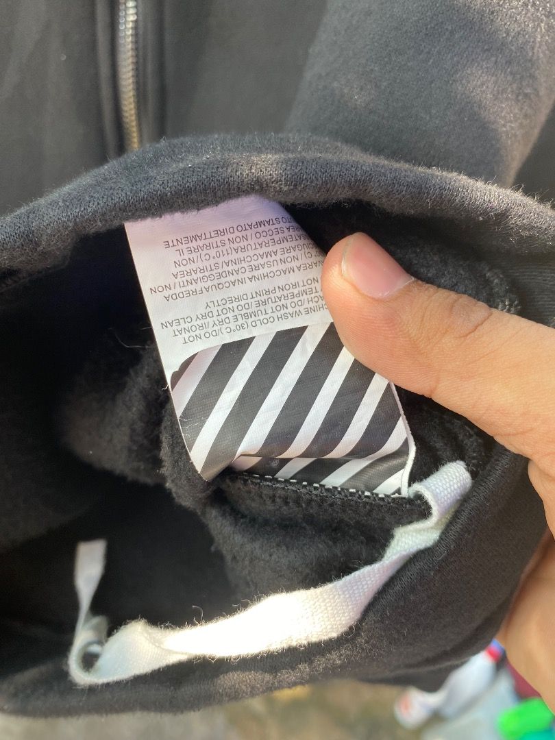 Offwhite Hoodie (Category: Coats, Jackets and Outerwear) located in Bacolod City. Submitted by chans_b_thrift (Listing ID 1465094670, Image 2). Description: - Color: Black - Closure: Front zipper with adjustable metal-aglet drawstrings - Pockets: Dual front pockets - Design: Eye-catching colorful patches on sleeves and iconic white diagonal stripes on the back and lower front - Interior: Warm and cozy fleece lining - Fit: Regular fit, true to siz