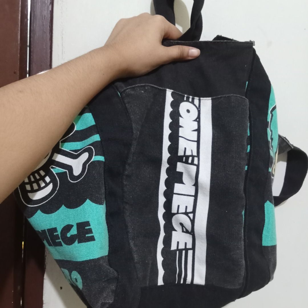 One Piece Anime Tote Bag (Category: Tote Bags) located in Quezon City. Submitted by trinket_cat (Listing ID 1464987690, Image 3). Description: - Design: Black canvas body with teal panels and bold white branding - Material: Cotton outer with polyester lining (Model: K-1918) - Perfect for: Daily use, school, or casual trips for anime fans - Condition: Good quality and ready to ship - Location: Metro Manila, Philippines (Fast shipping available!).