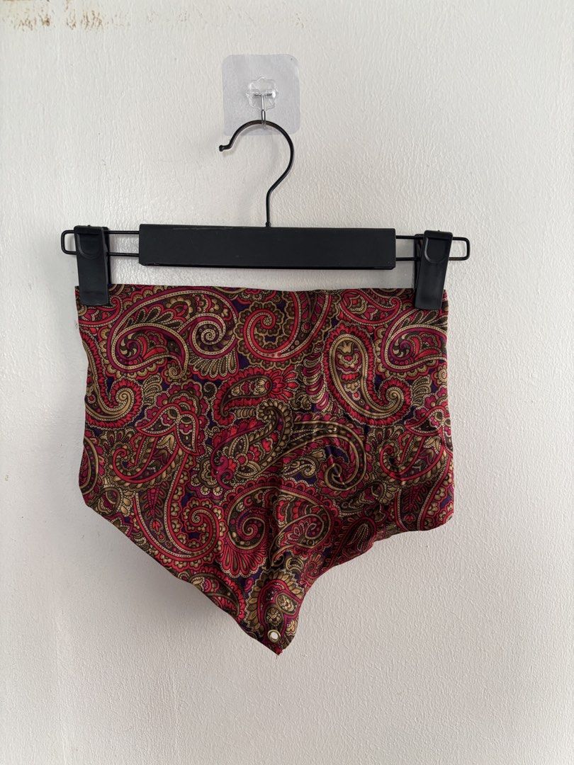 Paisley print lace-up back crop top (Category: Sleeveless) located in Muntinlupa City. Submitted by jc444_ (Listing ID 1465110741, Image 1). Description: - Style: Strapless bandeau top - Print/Color: Red and gold paisley - Details: Gold-toned metal grommets with light pink satin ribbon lace-up back - Hem: Unlined raw edge at the bottom point - Condition: Excellent.