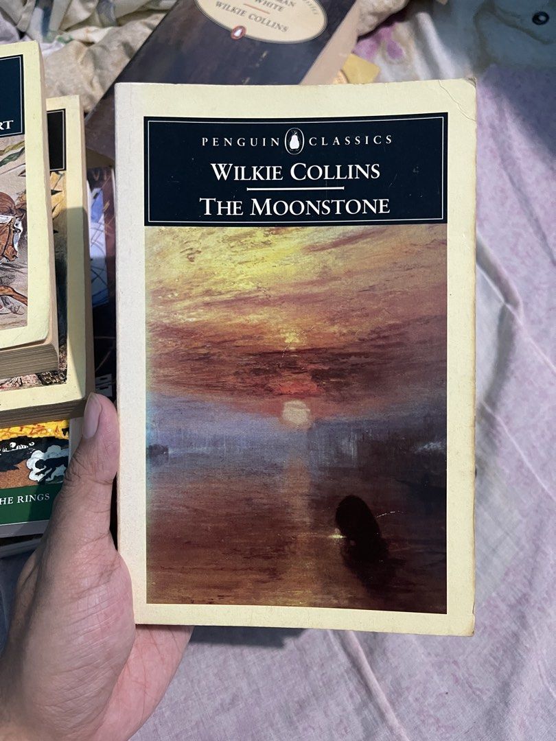 Penguin Classics The Moonstone by Wilkie Collins (Category: Storybooks) located in Bulacan. Submitted by keen72811 (Listing ID 1465099462, Image 1). Description: - Title & Author: The Moonstone by Wilkie Collins (Penguin Classics edition) - Genre: Classic mystery novel / The first modern detective story - Details: Edited with an introduction by J.I.M. Stewart - Cover: Features a classic J.M. Turner painting - Condition: Vintage paperback with pag
