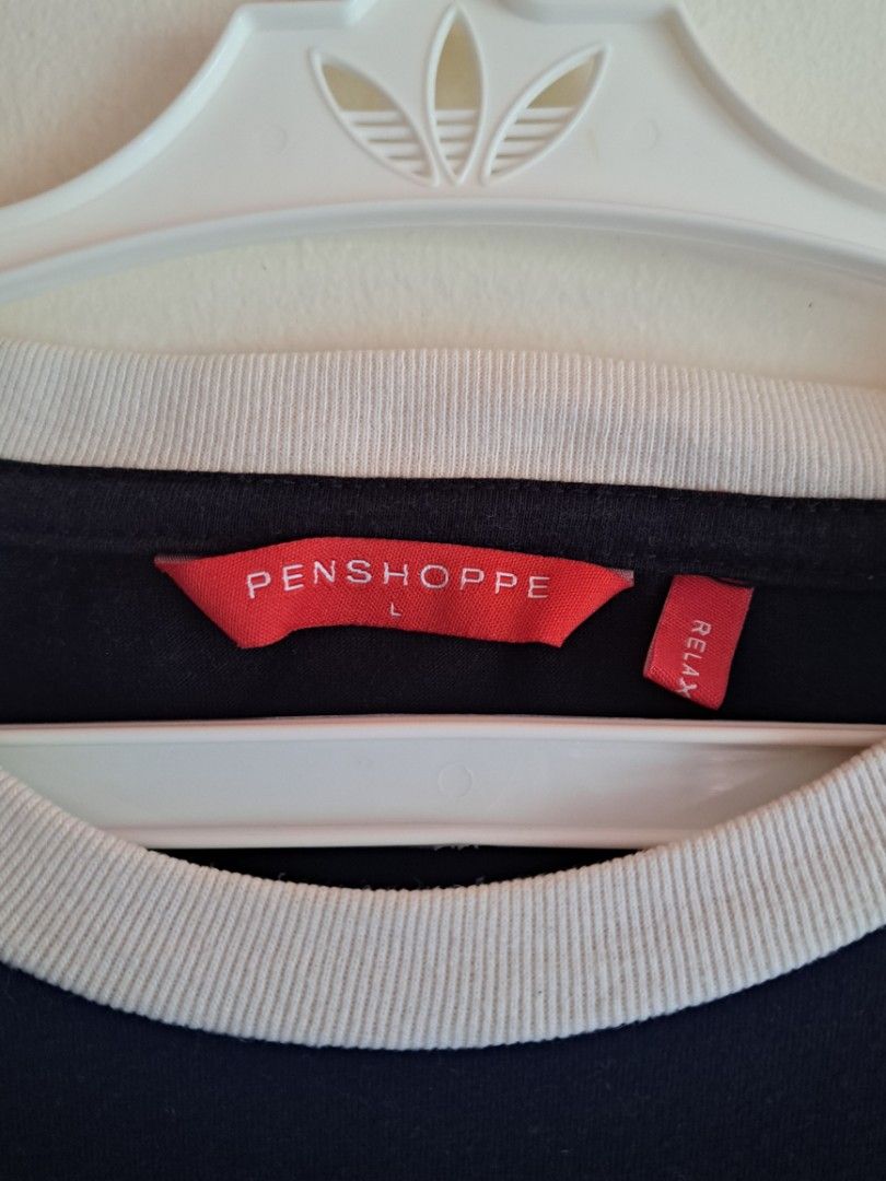 Penshoppe Black Ringer T-Shirt (Category: Shirts) located in Manila. Submitted by yselles__ (Listing ID 1464981921, Image 3). Description: - Color: Black with white ribbed collar and sleeve hems - Size: M-L (Red tag, relaxed fit style) - Material: Comfortable, high-quality cotton - Features: Branded white side tape detail along the torso - Condition/Style: Great for everyday casual wear.