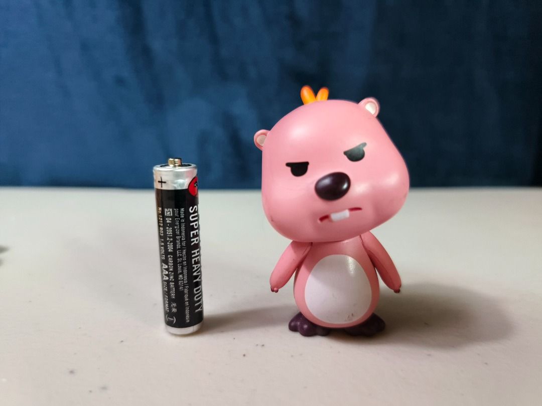 Pink Loopy Character Figurine Keychain Charm (Category: Charms) located in San Leonardo. Submitted by burgossanleonardo.12345 (Listing ID 1465050464, Image 1). Description: - Pink cartoon character figurine with an angry expression and white belly - Features a bright orange hair tuft and attached metal keyring loop - Compact, portable size (approx. AAA battery scale) - Official copyright marking stamped on the back of the head - Condition: Slight