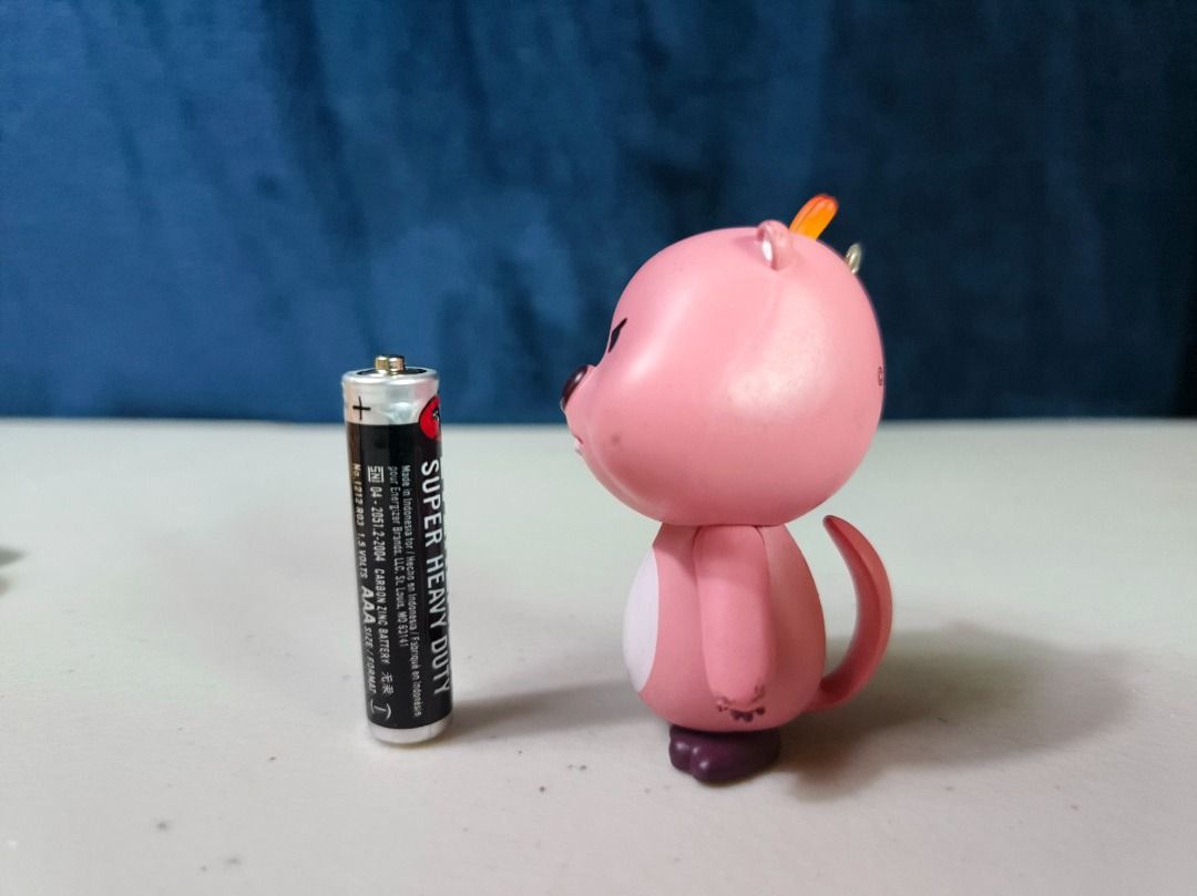 Pink Loopy Character Figurine Keychain Charm (Category: Charms) located in San Leonardo. Submitted by burgossanleonardo.12345 (Listing ID 1465050464, Image 2). Description: - Pink cartoon character figurine with an angry expression and white belly - Features a bright orange hair tuft and attached metal keyring loop - Compact, portable size (approx. AAA battery scale) - Official copyright marking stamped on the back of the head - Condition: Slight