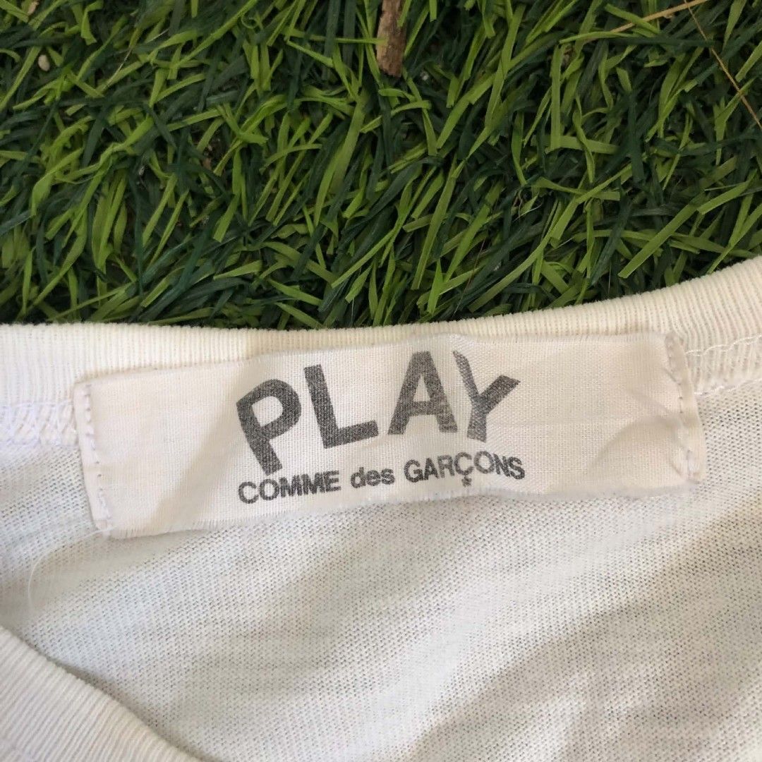 PLAY Comme des Garçons White Tee (Category: Shirts) located in Manila. Submitted by grandwater.53a8ce (Listing ID 1464987882, Image 2). Description: - Brand: PLAY Comme des Garçons - Color: Classic White - Design: Big bold front print with iconic red heart logo on the back - Fit: Short sleeves, round neckline - Material: 100% Premium Cotton (Made in Japan) - Care: Hand wash only - Condition: Excellent / Well-maintained - Message us for exact meas