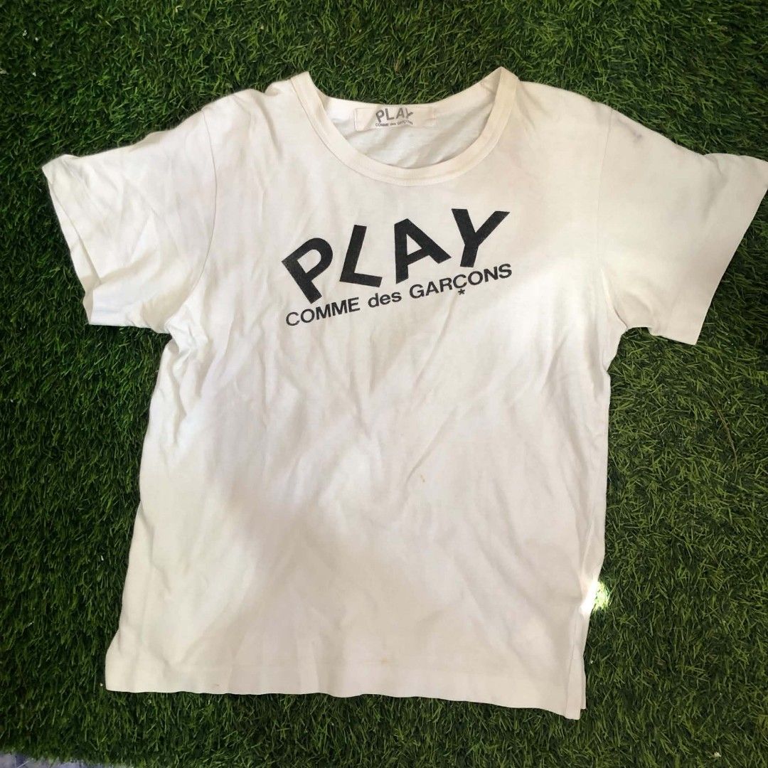 PLAY Comme des Garçons White Tee (Category: Shirts) located in Manila. Submitted by grandwater.53a8ce (Listing ID 1464987882, Image 1). Description: - Brand: PLAY Comme des Garçons - Color: Classic White - Design: Big bold front print with iconic red heart logo on the back - Fit: Short sleeves, round neckline - Material: 100% Premium Cotton (Made in Japan) - Care: Hand wash only - Condition: Excellent / Well-maintained - Message us for exact meas