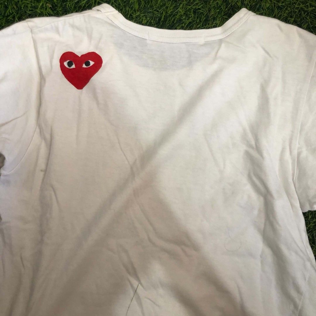 PLAY Comme des Garçons White Tee (Category: Shirts) located in Manila. Submitted by grandwater.53a8ce (Listing ID 1464987882, Image 3). Description: - Brand: PLAY Comme des Garçons - Color: Classic White - Design: Big bold front print with iconic red heart logo on the back - Fit: Short sleeves, round neckline - Material: 100% Premium Cotton (Made in Japan) - Care: Hand wash only - Condition: Excellent / Well-maintained - Message us for exact meas