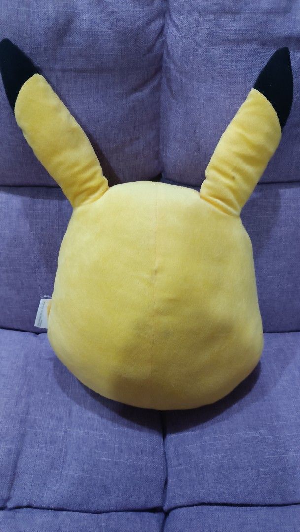 Pokémon Pikachu Head Plush Pillow (Category: Plushies & Soft Toys) located in Quezon City. Submitted by fabricatebycp (Listing ID 1465112774, Image 3). Description: Pikachu head plush pillow, bright yellow with red cheeks and embroidered smiling face. Measures roughly thirty centimeters across based on the ruler measurement shown. Tag says The ONE, includes copyright text dated 1997 Nintendo and Pokémon on the reverse side. Soft fabric material, 