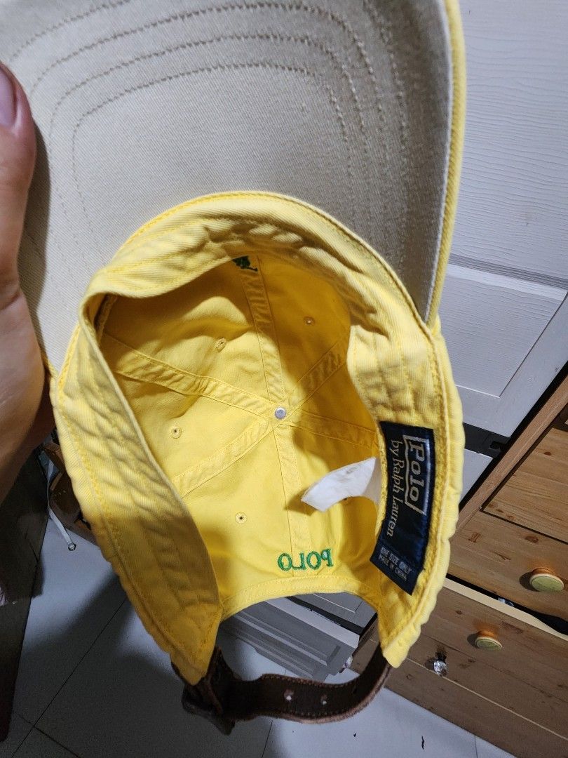 Polo by Ralph Lauren yellow cap (Category: Caps & Hats) located in Quezon City. Submitted by amber___18 (Listing ID 1465045823, Image 3). Description: - Brand: Ralph Lauren - Color: Bright yellow with green embroidered pony - Details: "POLO" stitched above the back opening and navy/white interior brand label - Fit: One size fits most with an adjustable brown leather strap and metal buckle.