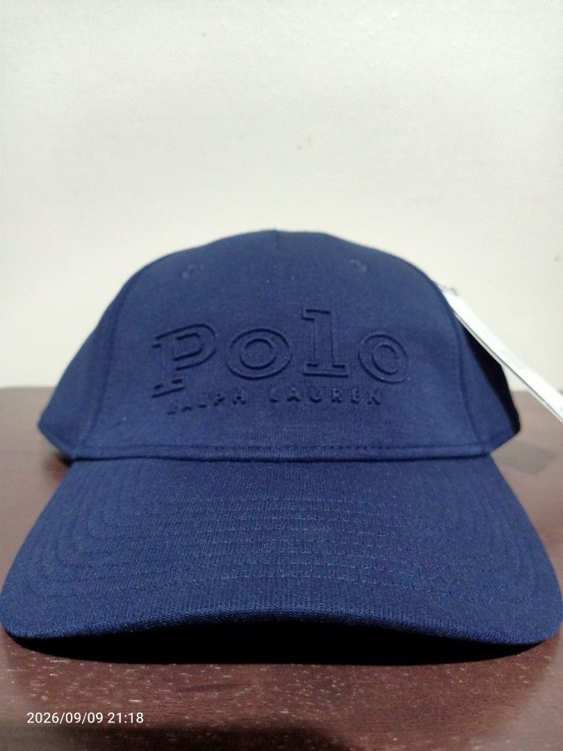 Polo Ralph Lauren Cap (Category: Caps & Hats) located in Las Pinas. Submitted by OmengSoyT (Listing ID 1464970581, Image 2). Description: - Brand: Polo Ralph Lauren - Color: Navy Blue - Condition: Brand new with original tags attached - Material: Combination of cotton and polyester materials - Design: Big embossed logo on front with smaller embroidered lettering on the back - Fit: (Osfa) Adjustable strap closure for a custom fit.