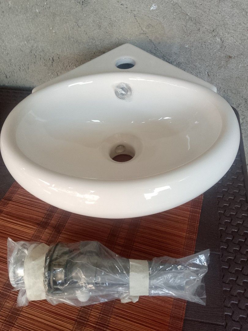 Pozzi PWT-2029 Corner Lavatory Sink (Category: Bathroom & Kitchen Fixtures) located in Taguig. Submitted by generygwap31973 (Listing ID 1465012463, Image 1). Description: - Brand: Pozzi (Model: PWT-2029) - Type: Grade A white ceramic corner lavatory sink - Condition: Unused porcelain with original factory sticker - Inclusions: Wrapped metal drain hardware pipe underneath - Finish: Clean and ready for bathroom installation.