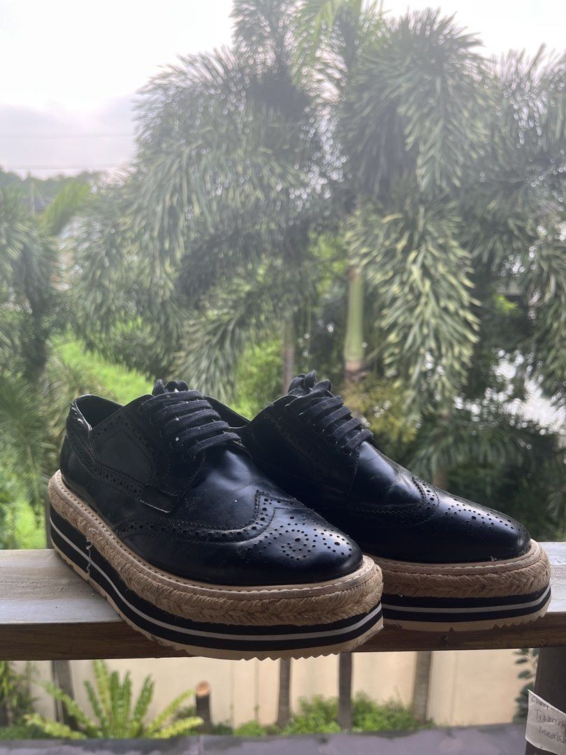Prada Black Leather Platform Brogue Shoes (Category: Loafers) located in Manila. Submitted by tanfinds (Listing ID 1464989321, Image 1). Description: - Brand: Prada - Style: Black leather wingtip brogues with statement espadrille platform sole - Details: Classic lace-up front, striped rubber midsole, and ridged outsole for extra grip - Branding: Prada logo stamped on insoles and rubber soles - Condition: Excellent / Well-maintained - Shipping or 