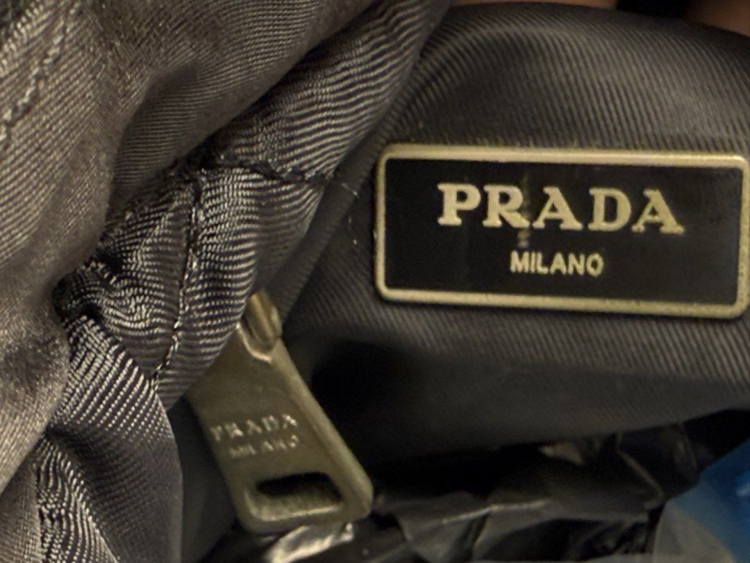 Prada Black Nylon Puffer Handbag Tote (Category: Luxury Bags & Wallets) located in Manila. Submitted by zuji.ph (Listing ID 1464995783, Image 2). Description: -black Prada puffer nylon tote bag - Iconic front triangle logo plaque and sleek silver-tone hardware - Practical double top handles and secure top zip closure with Lampo zipper pull - Convenient zippered outer pocket on the front body - Fully lined black fabric interior with Prada Milano m