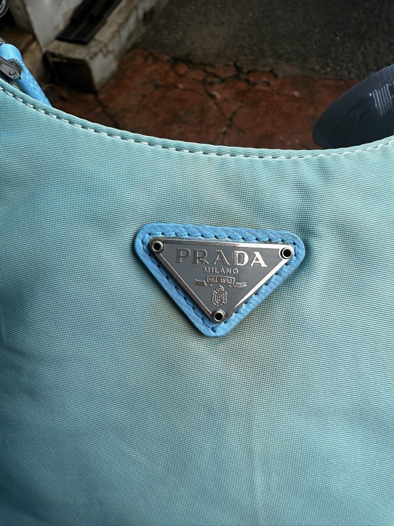 Prada Re-Edition Nylon Shoulder Bag Light Blue (Category: Luxury Bags & Wallets) located in Quezon City. Submitted by la.deals (Listing ID 1465022499, Image 3). Description: Authentic Prada Re-Nylon - Authentic light blue Prada nylon shoulder bag - Silver-tone hardware with signature front logo plaque - Includes two interchangeable straps: elegant chain strap and extra wide branded fabric strap - Secure top zip closure - Clean interior with Prada