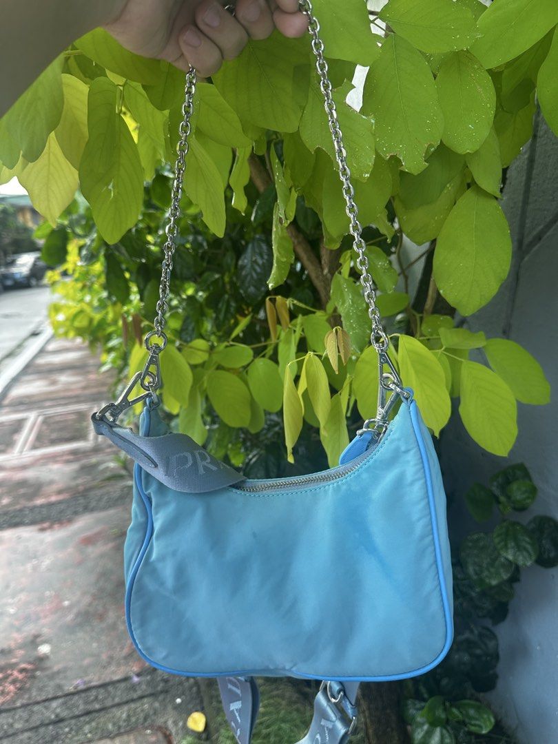Prada Re-Edition Nylon Shoulder Bag Light Blue (Category: Luxury Bags & Wallets) located in Quezon City. Submitted by la.deals (Listing ID 1465022499, Image 2). Description: Authentic Prada Re-Nylon - Authentic light blue Prada nylon shoulder bag - Silver-tone hardware with signature front logo plaque - Includes two interchangeable straps: elegant chain strap and extra wide branded fabric strap - Secure top zip closure - Clean interior with Prada
