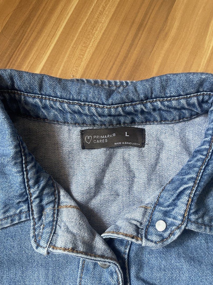 Primark Denim Cropped Polo (Category: Shirts) located in Antipolo. Submitted by wh0smarga (Listing ID 1464989088, Image 2). Description: - Brand/Line: Primark Cares - Size: Large to Semi XL - Color: Blue wash - Style: Cropped fit denim polo - Details: Button-up front with silver-tone metal buttons, classic collar neck, two chest pockets - Fabric: Soft denim, great for layering or wearing solo.