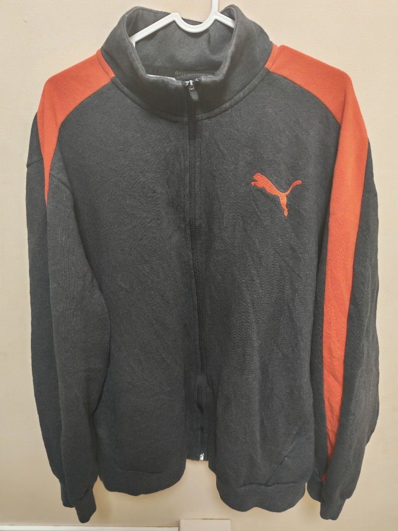 Puma Track Jacket Black Orange Zip Up (Category: Coats, Jackets and Outerwear) located in Manila. Submitted by gerwin1990 (Listing ID 1465077438, Image 1). Description: Dark grey and orange Puma track jacket. Full zip front with stand-up collar. Contrast orange stripes run down each sleeve. Embroidered orange Puma logo on the chest. Ribbed cuffs and hem. Great layering piece for workouts or casual wear. Grab it before it's gone..