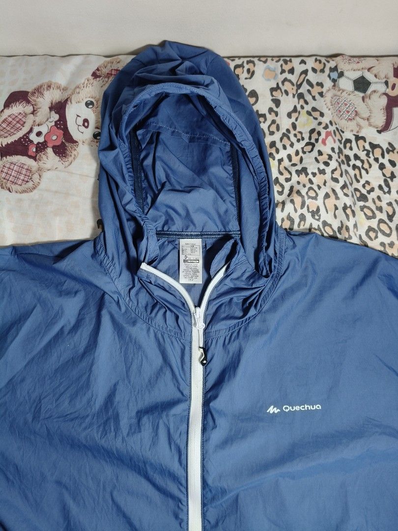 Quechua Helium 500 UV Protection Hiking Jacket (Category: Activewear) located in Lapu Lapu. Submitted by hooman422 (Listing ID 1465069233, Image 2). Description: • Type: Lightweight windbreaker and sun protection hiking jacket. • Color: Two-tone blue (lighter blue on the top panel and sleeves, darker navy blue on the bottom half). • Design Features: Full-length white central zipper, built-in hood, two zippered hand pockets with white trim, and sm