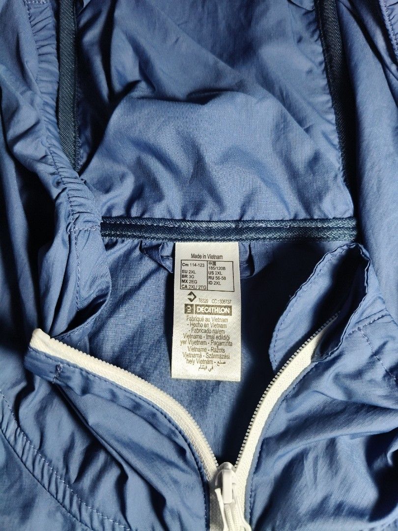 Quechua Helium 500 UV Protection Hiking Jacket (Category: Activewear) located in Lapu Lapu. Submitted by hooman422 (Listing ID 1465069233, Image 3). Description: • Type: Lightweight windbreaker and sun protection hiking jacket. • Color: Two-tone blue (lighter blue on the top panel and sleeves, darker navy blue on the bottom half). • Design Features: Full-length white central zipper, built-in hood, two zippered hand pockets with white trim, and sm