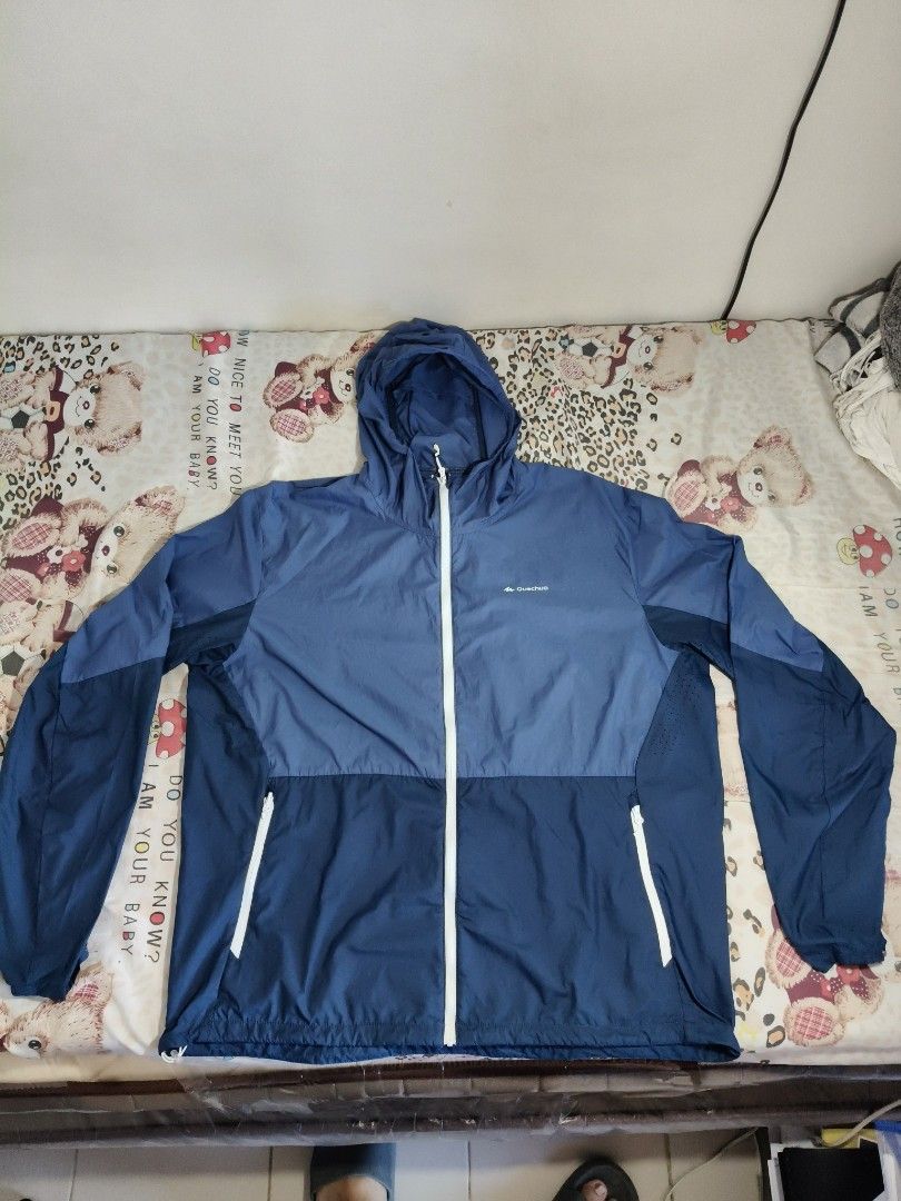 Quechua Helium 500 UV Protection Hiking Jacket (Category: Activewear) located in Lapu Lapu. Submitted by hooman422 (Listing ID 1465069233, Image 1). Description: • Type: Lightweight windbreaker and sun protection hiking jacket. • Color: Two-tone blue (lighter blue on the top panel and sleeves, darker navy blue on the bottom half). • Design Features: Full-length white central zipper, built-in hood, two zippered hand pockets with white trim, and sm