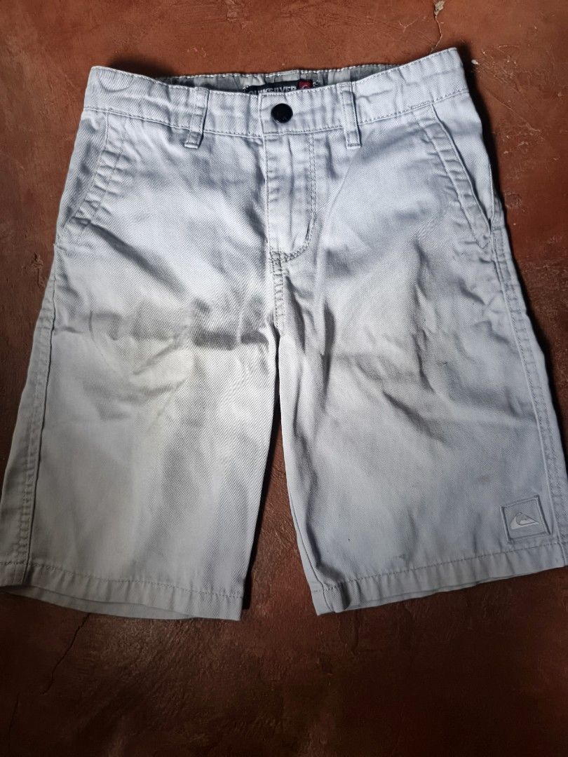 Quiksilver Boy's Shorts Size 7 (Category: Babies & Kids Fashion) located in Gumaca. Submitted by makuliti (Listing ID 1464978035, Image 1). Description: - Brand: Quiksilver - Item: Boy's casual shorts - Color: Light grey - Size: L/G/7 - Details: Button closure, front pockets, belt loops, and embroidered logo patch on lower left leg - Condition: Authentic with inner brand and RN tags.