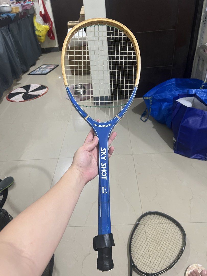 Rainbow Sky Shot E TS-900 Tennis Racket (Category: Racket and Ball Sports) located in Manila. Submitted by ajdfinds (Listing ID 1465003422, Image 1). Description: - Model: Rainbow Sky Shot E TS-900 (Made in Taiwan) - Design: Blue frame with a stylish wooden top accent and white strings - Grip: Black grip tape with an 'E' logo on the bottom cap - Condition: Normal wear on the paint and frame from previous play - Great for casual play or collectors