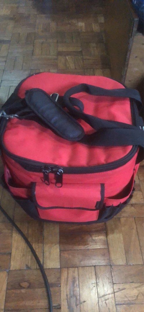 Red and black multi-pocket storage bag with strap (Category: Fishing) located in Manila. Submitted by paps08 (Listing ID 1465085317, Image 1). Description: - Color: Red with stylish black trim - Storage: Main zippered compartment on top for secure storage - Organization: Multiple exterior pockets on the front and sides for small tools and accessories - Comfort: Includes a padded shoulder strap for easy and comfortable carrying - Condition: Brand 