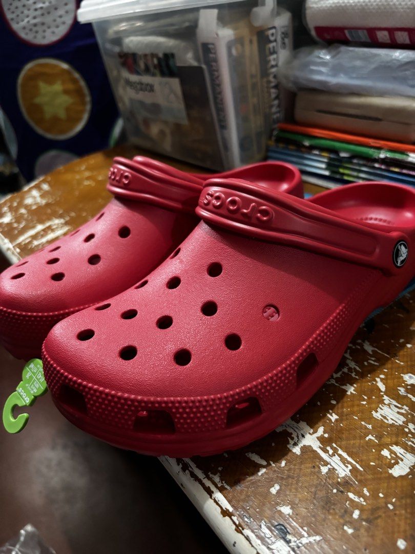 Red Crocs Classic Clogs Size M8 W10 (Category: Slippers & Slides) located in Mandaluyong City. Submitted by aceandres (Listing ID 1464989892, Image 2). Description: - Item: Crocs Classic Clogs - Color: Bright Red - Size: Men's 8 / Women's 10 - Condition: Brand new with original tags attached - Origin: Made in Indonesia - Features: Slip-on design, breathable ventilation holes, and secure heel strap.