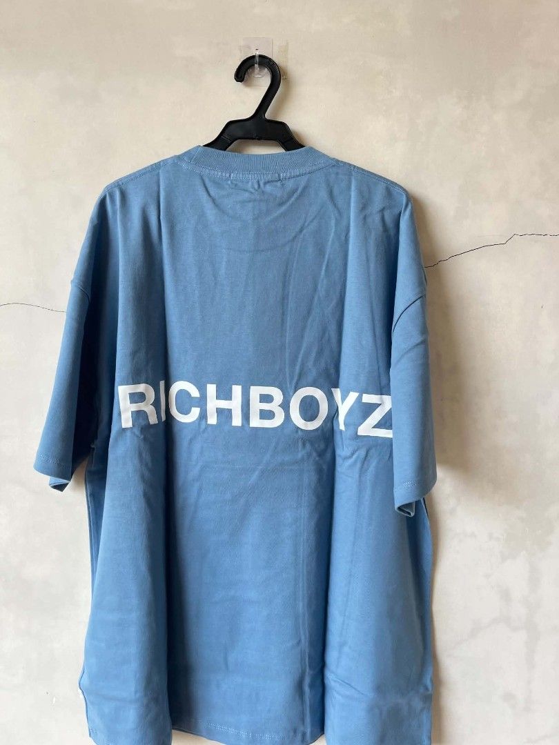 RICHBOYZ Blue Graphic Oversized T-shirt (Category: Tshirts & Polo Shirts ) located in Iloilo. Submitted by franzventures (Listing ID 1464971360, Image 2). Description: - Brand: RICHBOYZ - Color: Light blue - Fit: Oversized streetwear cut - Details: Small text print on chest, large white RICHBOYZ lettering on back - Neckline/Sleeves: Crew neck with short sleeves - Condition: Excellent, clean fabric with no stains or fading.