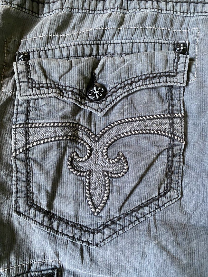 Rock Revival Grey Cargo Shorts Size 36 (Category: Shorts) located in Manila. Submitted by diporosmoh43681 (Listing ID 1465000390, Image 3). Description: - Brand: Rock Revival - Style: Cargo shorts in grey corduroy-textured fabric - Size: 36 (indicated on waistband label) - Pockets: Multiple utility pockets including buttoned cargo side pockets and flapped rear pockets - Details: Signature rear pocket embroidery, stylish topstitching throughout, a
