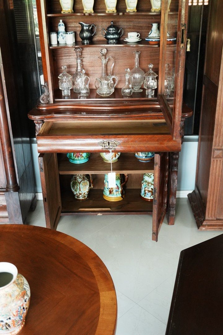 Rococo-Style Wooden Display Cabinet (Category: Shelves, Cabinets & Racks) located in Manila. Submitted by heleensym (Listing ID 1464971278, Image 3). Description: Elegant display cabinet featuring an ornate carved crest, a shaped glass-front door and three interior shelves. A wide drawer and enclosed two-door cupboard provide additional storage below. Rich brown finish with decorative carved details and a gracefully curved profile. Condition: Vis