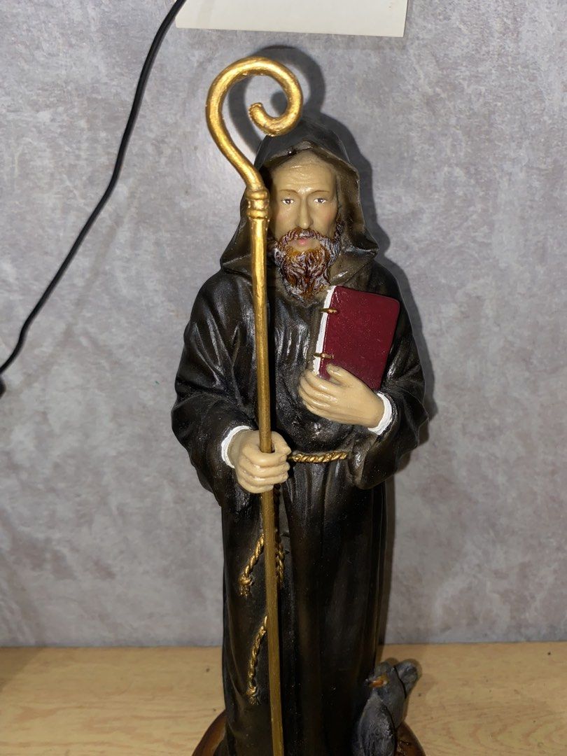 Saint Benedict/ St. Benedict Statue (Category: Figurines & Statues) located in Rizal. Submitted by lorens_villaflores28 (Listing ID 1464978594, Image 1). Description: - Material: Hand-painted resin with textured clothing and detailed facial features - Design: Bearded monk in a dark hooded robe holding a golden staff and red book, with a small bird near his feet - Base: Securely mounted on a round wooden base - Condition: Excellent, well-maintaine