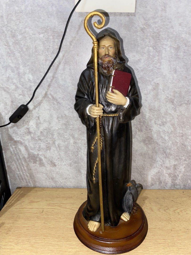 Saint Benedict/ St. Benedict Statue (Category: Figurines & Statues) located in Rizal. Submitted by lorens_villaflores28 (Listing ID 1464978594, Image 2). Description: - Material: Hand-painted resin with textured clothing and detailed facial features - Design: Bearded monk in a dark hooded robe holding a golden staff and red book, with a small bird near his feet - Base: Securely mounted on a round wooden base - Condition: Excellent, well-maintaine