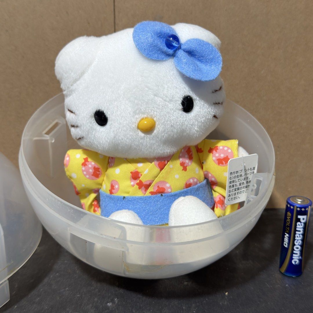 Sanrio Hello Kitty Kimono Plush with Plastic Capsule Eikoh (Category: Plushies & Soft Toys) located in Cuyapo. Submitted by blacksheepshop (Listing ID 1464979040, Image 2). Description: - Authentic Eikoh Kitty plush in a yellow yukata featuring red and pink patterns - Accented with a cute blue bow and matching blue obi sash - Holding a traditional red paper fan with Japanese text - Vintage piece with 1976 and 2002 Sanrio copyright markings - Come