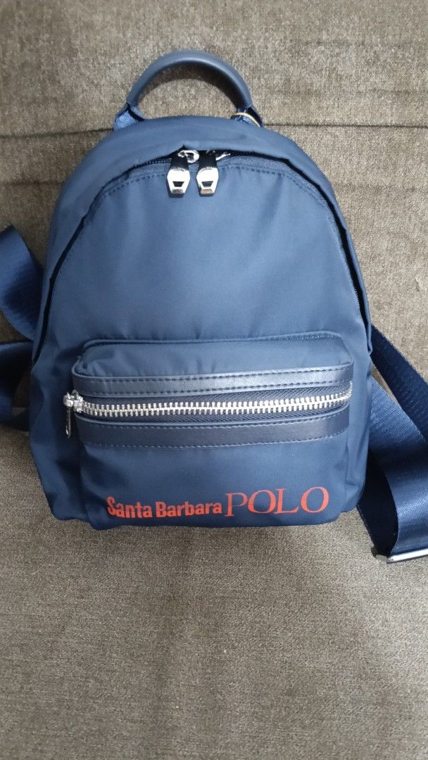 Santa Barbara Polo Navy Blue Nylon Backpack (Category: Backpacks) located in Cebu City. Submitted by mcmapio (Listing ID 1465059383, Image 1). Description: - Brand: Santa Barbara Polo - Size: Mini / Small Backpack - Color: Navy blue with bold red logo and silver-tone hardware - Material: Durable nylon - Compartments: Secure front zipper pocket - Straps: Convenient top handle and adjustable shoulder straps - Condition: Clean exterior, smooth worki