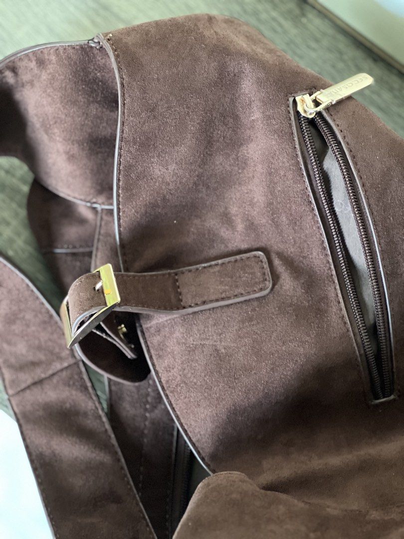 Secosana Brown Suede Shoulder Hobo Bag (Category: Shoulder Bags) located in Pili. Submitted by gaellecast (Listing ID 1464969187, Image 2). Description: - Brand: Secosana - Material: Rich brown suede with soft, slouchy body - Hardware: Gold-toned throughout - Pockets: Exterior zippered pocket and fabric-lined interior with an additional zippered pocket - Closure: Front buckle accent with metallic snap button - Strap: Comfortable shoulder strap in