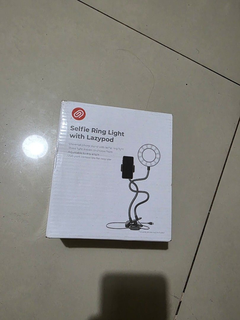 Selfie Ring Light with Lazypod Phone Stand (Category: Lighting & Studio Equipment) located in Manila. Submitted by argana584 (Listing ID 1465112322, Image 1). Description: - Brand new & unopened box: Everything is packed safely inside - 3 Light Modes: Easily switch between lighting tones for any setting - Flexible Gooseneck Arms: Bend and adjust the phone stand and light to any angle - USB Powered: Conveniently plug into your laptop, power bank, 
