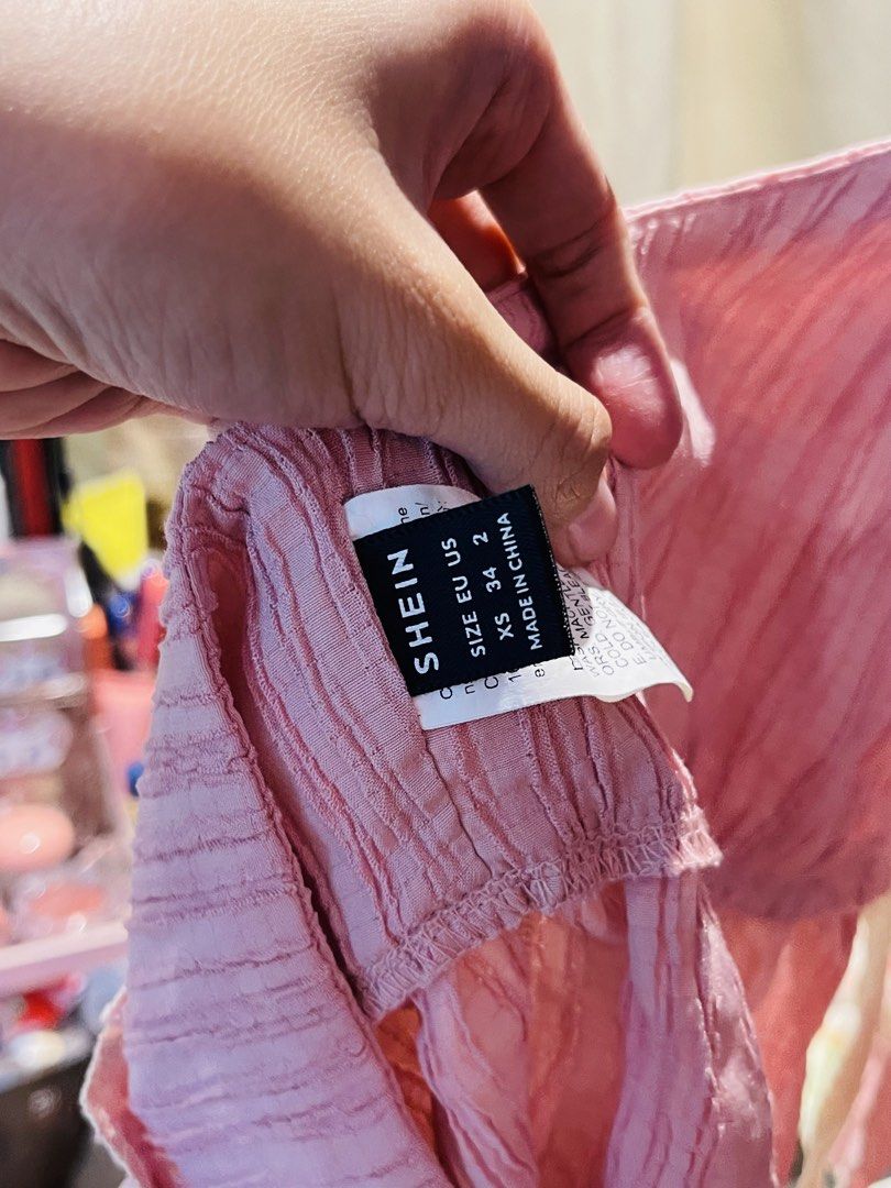 SHEIN Pink Halter Crop Top Size XS (Category: Sleeveless) located in San Mateo. Submitted by precious.03 (Listing ID 1464998280, Image 3). Description: - Brand: Shein - Size: XS (EU 34, US 2) - Brand new with tag attached - Color: Pink - Material & Design: Light & breezy crinkle texture fabric with self-tie straps at the neck and front - Details: Charming ruffle trim along the bottom hem and edges - Perfect for: Warm weather, beach trips, or casu