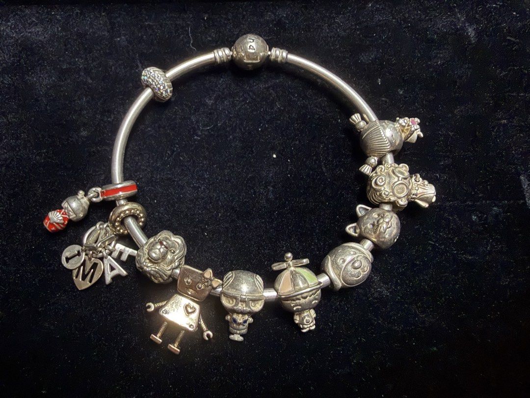 Silver Charm Bracelet with Multiple Charms (Category: Bracelets) located in Manila. Submitted by aybi.7.3.1 (Listing ID 1465027628, Image 1). Description: Authentic Pandora Bangle with 10 Charms + Stopper Charms: • Japanese Girl • Family • Lion Head • Rose Gold Robot Girl • Father • Boy • Dog • Cat • Mother • Girl.