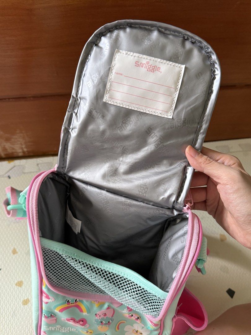 Smiggle Flower Lunch Box Bag with Rainbow Strap (Category: Shoulder Bags) located in Cebu City. Submitted by limjennif52235 (Listing ID 1464979865, Image 3). Description: - Authentic Smiggle insulated lunch bag in a mint green, pink, and yellow colorway - Features fun floral, rainbow, and ice cream graphics with a big smiling flower patch - Keeps food fresh with a silver insulated lining and includes a name tag label under the lid - Offers extra 