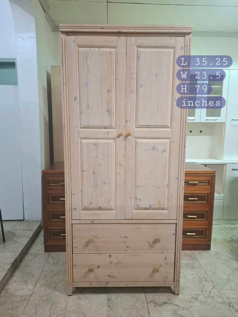 Solid Wood Wardrobe With Double Doors And Drawers (Category: Shelves, Cabinets & Racks) located in Quezon City. Submitted by japandemanila (Listing ID 1465006858, Image 1). Description: - Material: Solid pine with natural wood grain and knots - Storage: Double doors with a spacious interior and hanging rail - Drawers: Two large bottom drawers on smooth metal tracks with wooden knobs - Build: Sturdy construction featuring clean interior woodwork.