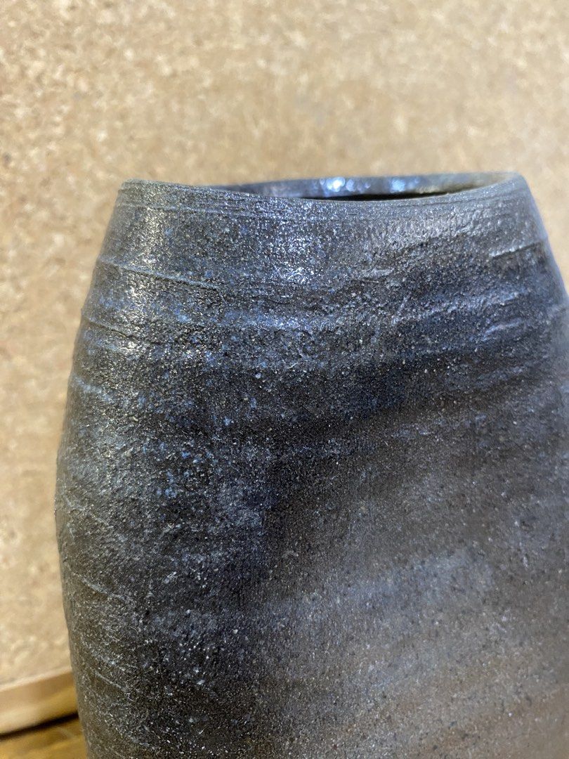 Stoneware Indented Shape Decorative Vase (Category: Vases & Decorative Bowls) located in Calamba. Submitted by chebvintagedepot (Listing ID 1465022222, Image 2). Description: [B26-02] This decorative ceramic vase has a rustic dark charcoal finish with subtle horizontal ribbing and a unique organic indented shape. Made from stoneware, it has a simple textured look that works well with a variety of home décor styles. The unusual shape adds visual i