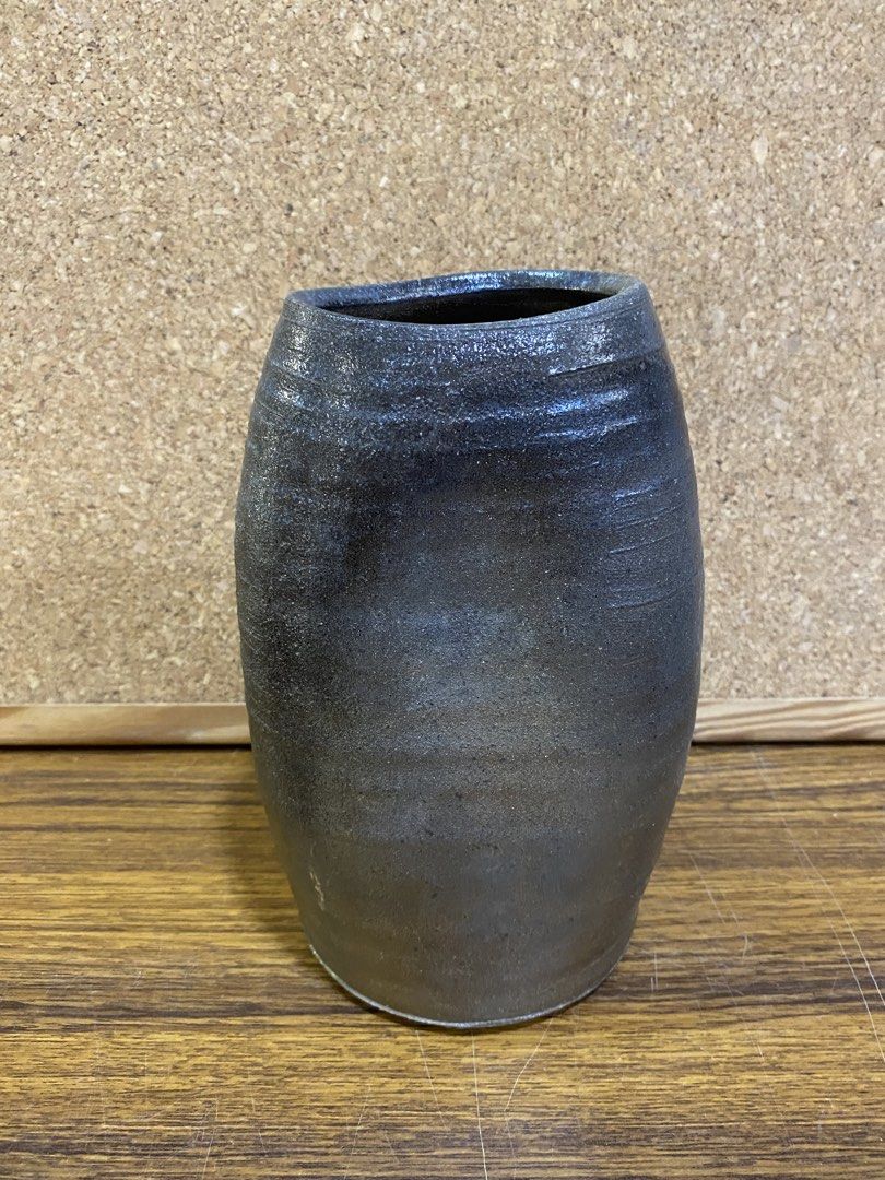 Stoneware Indented Shape Decorative Vase (Category: Vases & Decorative Bowls) located in Calamba. Submitted by chebvintagedepot (Listing ID 1465022222, Image 1). Description: [B26-02] This decorative ceramic vase has a rustic dark charcoal finish with subtle horizontal ribbing and a unique organic indented shape. Made from stoneware, it has a simple textured look that works well with a variety of home décor styles. The unusual shape adds visual i