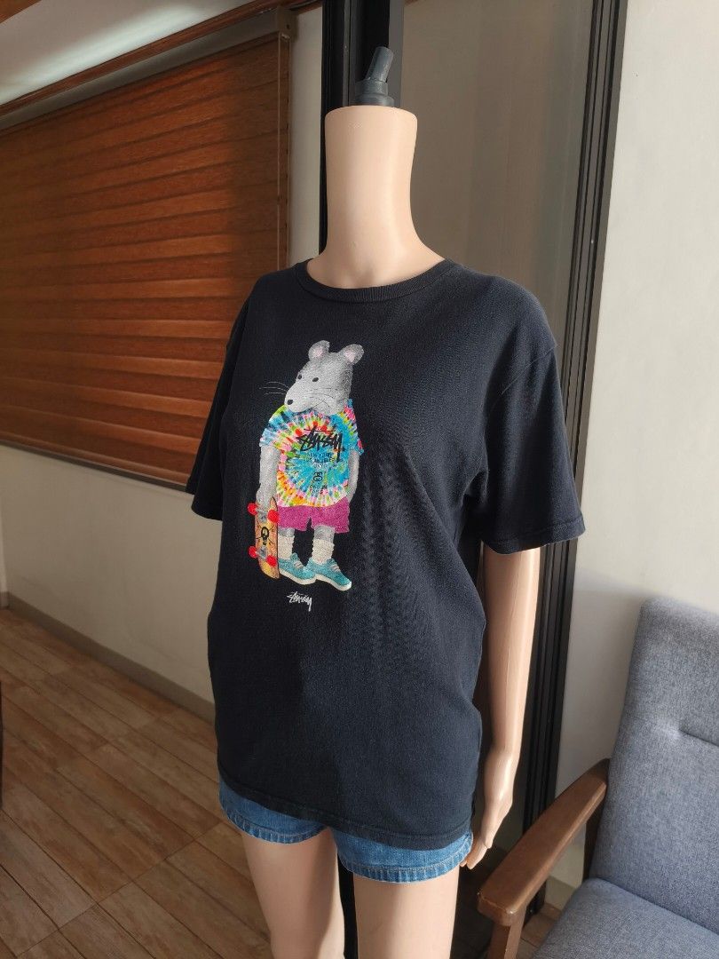Stussy Skate Rat Graphic Tee (Category: Tshirts & Polo Shirts ) located in Siniloan. Submitted by wingedwardrobe (Listing ID 1445063626, Image 1). Description: W19.5 L27 Size M Front graphic of a skater rat/mouse character wearing a tie-dye Stüssy World Tour tee, pink shorts, teal sneakers, and holding a skateboard. Small Stüssy logo print below graphic. 📢 𝐒𝐇𝐎𝐏 𝐑𝐄𝐌𝐈𝐍𝐃𝐄𝐑𝐒 📢 - 𝐒𝐢𝐳𝐞𝐬 𝐚𝐫𝐞 𝐚𝐩𝐩𝐫𝐨𝐱𝐢𝐦𝐚𝐭𝐞. 𝐏𝐥𝐞𝐚𝐬𝐞 𝐦
