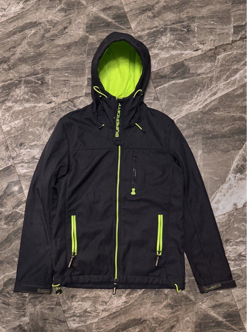 Superdry Neon Lined Hooded Softshell Jacket Black (Category: Coats, Jackets and Outerwear) located in Alaminos. Submitted by outfitcheck.ph (Listing ID 1465109669, Image 1). Description: - Authentic Superdry softshell jacket in sleek black - Warm neon green fleece-lined hood with adjustable drawstrings - Eye-catching neon green front and pocket zippers - Convenient zippered chest pocket for secure storage - Adjustable drawstring hem for a customi