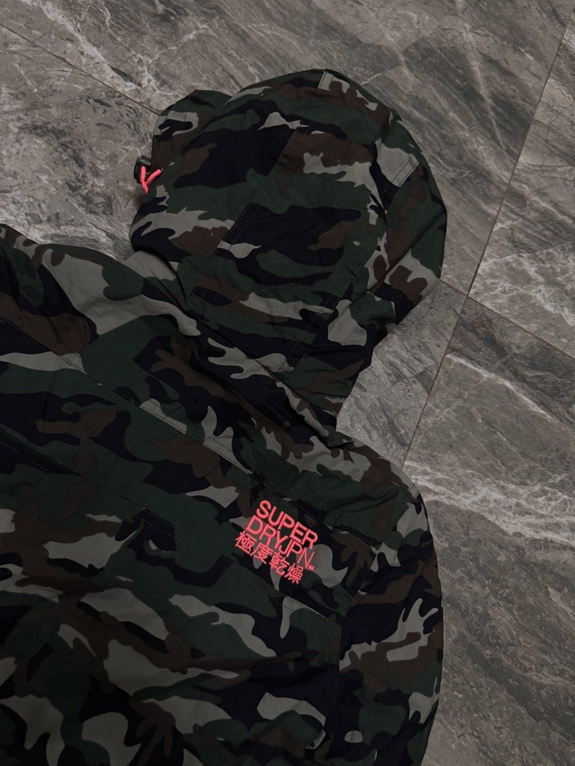 Superdry Professional The Windcheater Camo Jacket (Category: Coats, Jackets and Outerwear) located in Alaminos. Submitted by outfitcheck.ph (Listing ID 1465110296, Image 3). Description: Superdry Professional The Windcheater jacket in green camouflage pattern. Bright neon pink lining inside the hood and collar, matching pink embroidery details on the shoulder and back. Double zip closure with toggle pull cords. Ribbed inner collar for extra warmt